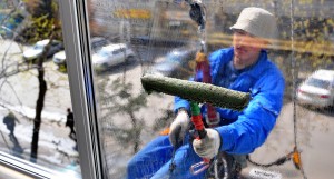Промышленный альпинист Мухтар Хаджиматов моет окна здания в Бумажном проезде